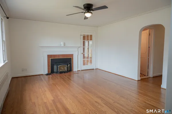 a view of empty room with wooden floor and fireplace