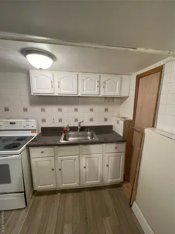 a kitchen with stainless steel appliances a sink a stove a refrigerator and wooden cabinets