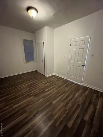 an empty room with wooden floor and closet