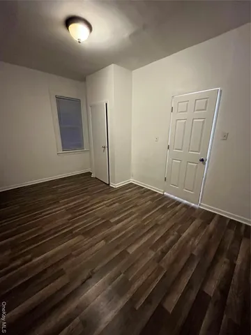 an empty room with wooden floor and closet
