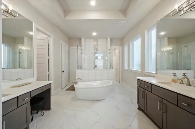 a bathroom with a double vanity sink a mirror and a bathtub