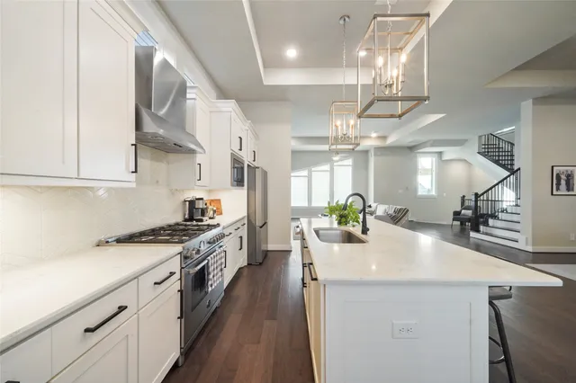 a kitchen with stainless steel appliances a sink a stove top oven a counter space and cabinets