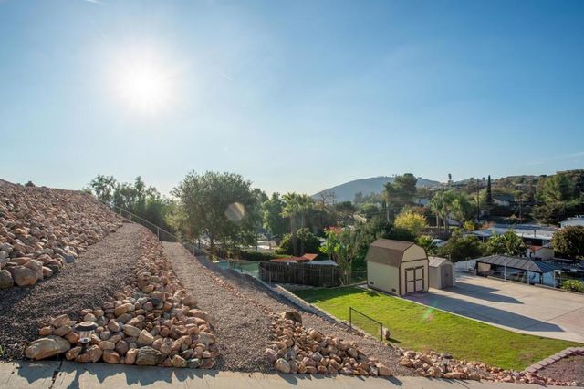 a living room with furniture a chandelier and a floor to ceiling window