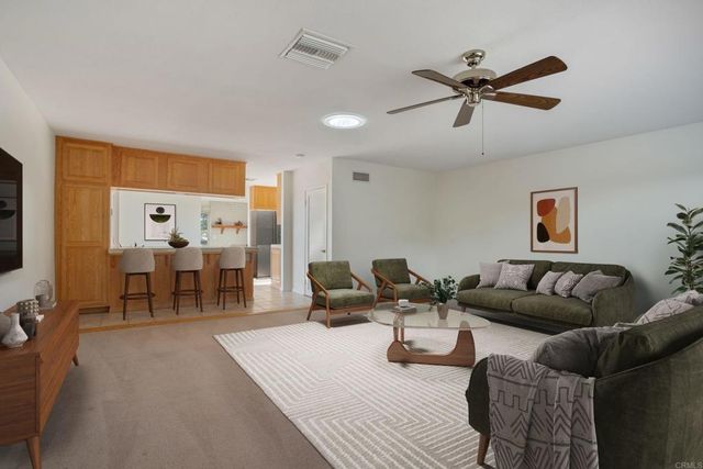 a view of a livingroom with a ceiling fan and window