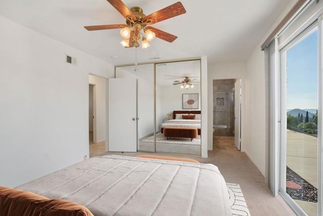 an empty room with windows and fan