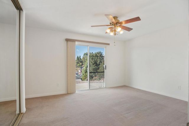 a view of house with backyard and trees in the background