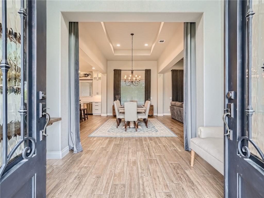 132 Huerta Road Florence, TX 76527 - Photo 2 of 40 Enter into a thoughtfully designed space with an elegant dining area, visible through ornate double doors.