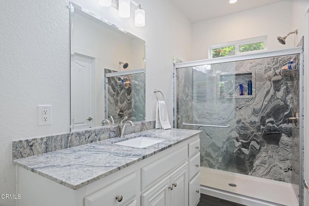 11100 Telegraph Road, Unit 88 Ventura, CA 93004 - Photo 12 of 24 a bathroom with a granite countertop sink a mirror and shower