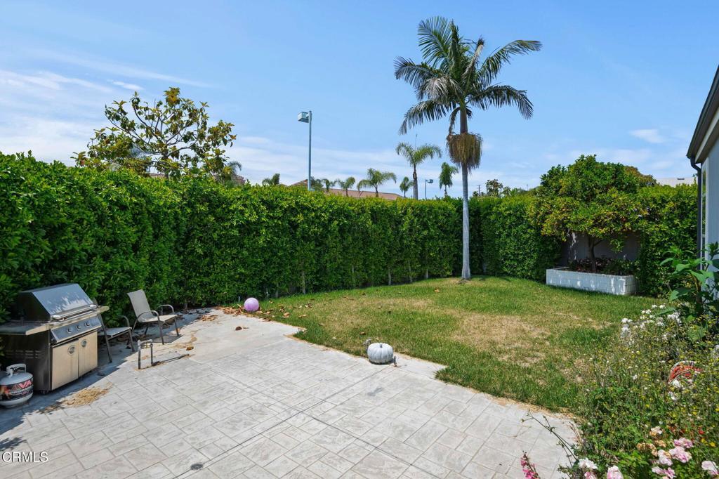 11100 Telegraph Road, Unit 88 Ventura, CA 93004 - Photo 19 of 24 a backyard of a house with table and chairs potted plants and palm trees