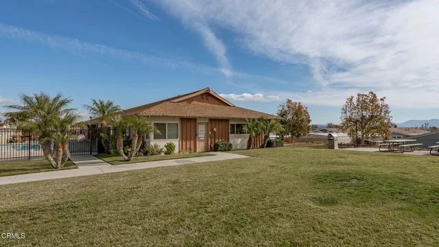 a front view of a house with a yard and trees
