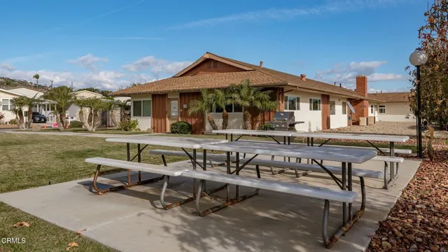a view of a patio with table and chairs with wooden floor and fence