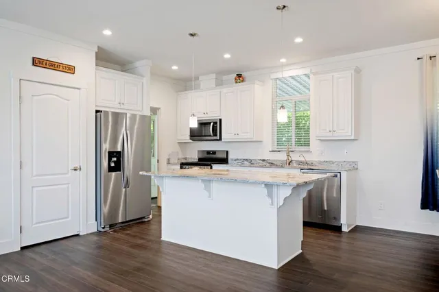 a kitchen with stainless steel appliances a refrigerator stove microwave and sink