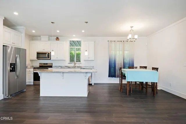 a kitchen with a table chairs refrigerator and cabinets