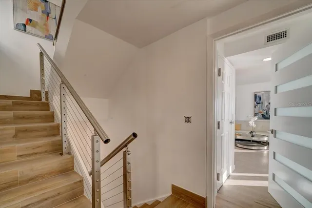 a view of a hallway with wooden floor and staircase