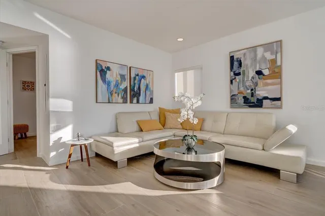 a living room with furniture and a painting on the wall