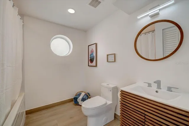 a bathroom with a toilet a sink and mirror