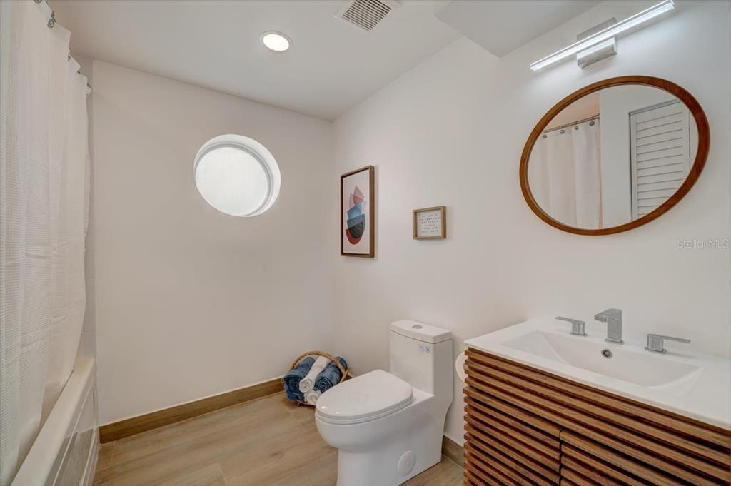 17852 Lee Avenue Redington Shores, FL 33708 - Photo 32 of 38 a bathroom with a toilet a sink and mirror