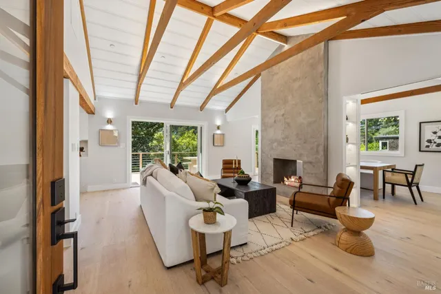 a living room with furniture a fireplace and a floor to ceiling window