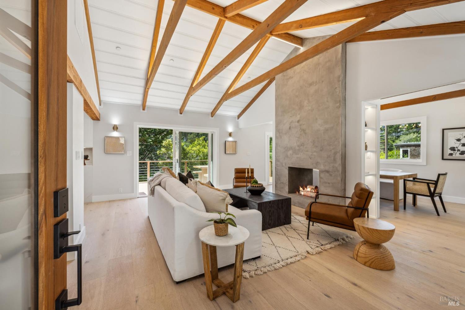 a living room with furniture a fireplace and a floor to ceiling window