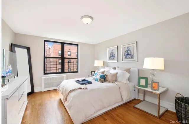 a bedroom with a bed a dresser next to a window