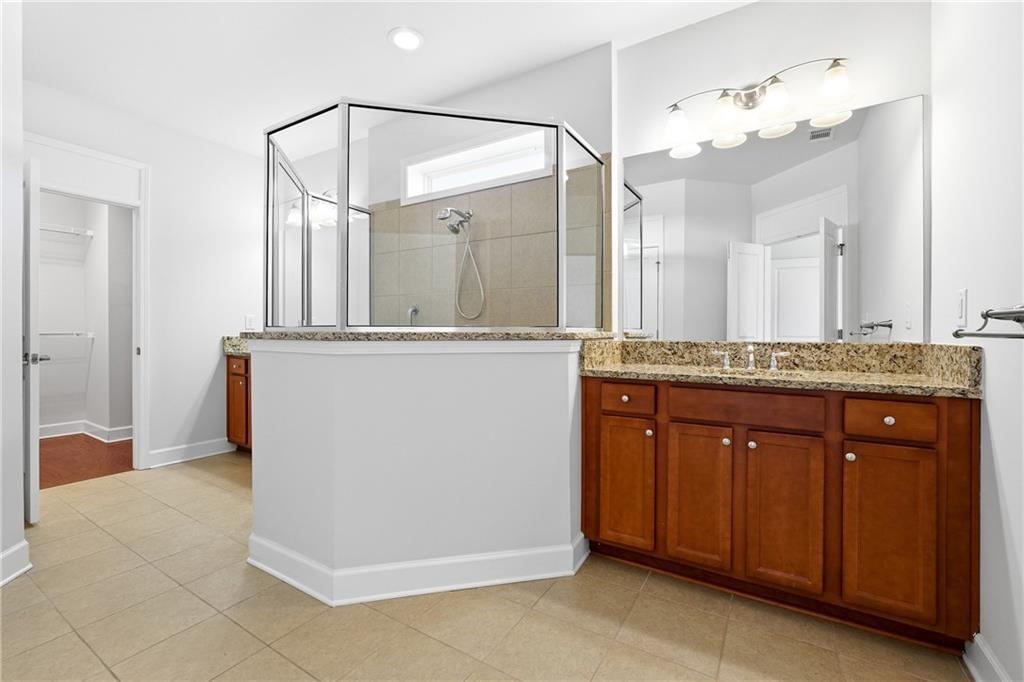 3751 Golden Leaf Point Southwest Gainesville, GA 30504 - Photo 16 of 45 a bathroom with a granite countertop sink a mirror and a vanity