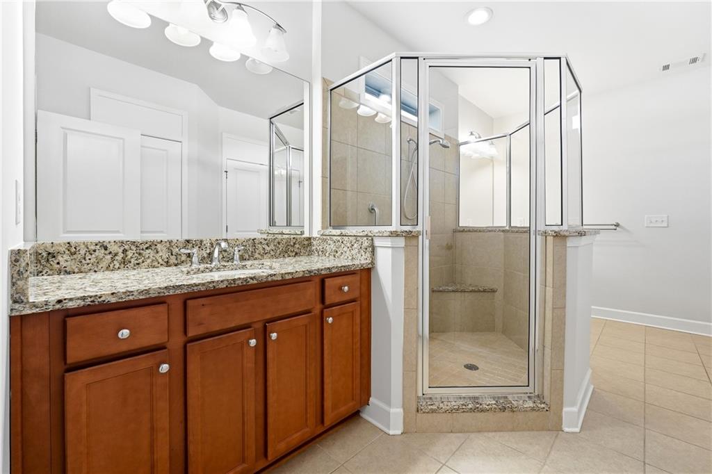 3751 Golden Leaf Point Southwest Gainesville, GA 30504 - Photo 17 of 45 a bathroom with a granite countertop sink a mirror and shower