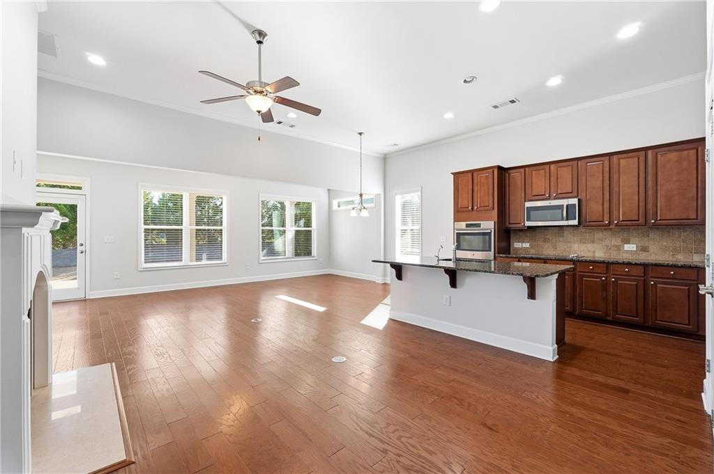 3751 Golden Leaf Point Southwest Gainesville, GA 30504 - Photo 3 of 45 a large kitchen with stainless steel appliances granite countertop a stove a sink a refrigerator a center island and wooden floor
