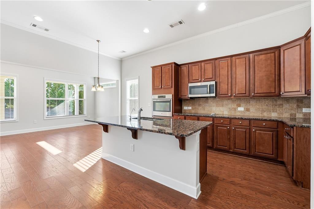 3751 Golden Leaf Point Southwest Gainesville, GA 30504 - Photo 4 of 45 a kitchen with stainless steel appliances granite countertop a sink refrigerator stove and microwave