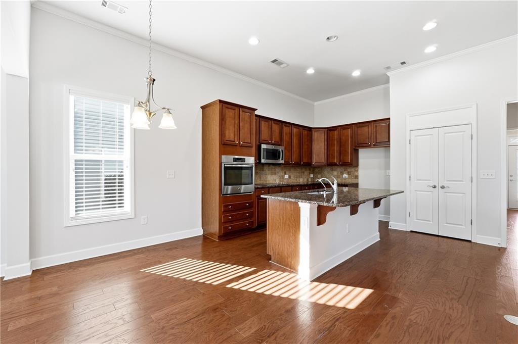 3751 Golden Leaf Point Southwest Gainesville, GA 30504 - Photo 5 of 45 a kitchen with stainless steel appliances kitchen island granite countertop a stove a sink and a refrigerator
