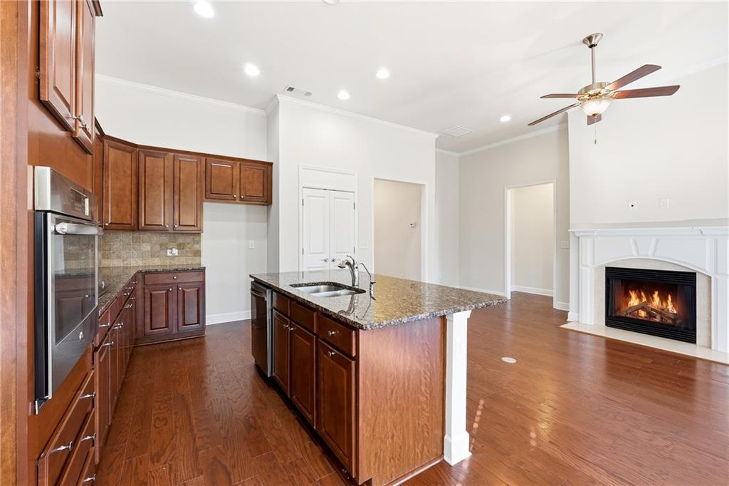 3751 Golden Leaf Point Southwest Gainesville, GA 30504 - Photo 6 of 45 a kitchen with stainless steel appliances granite countertop a stove top oven a sink and a wooden floors