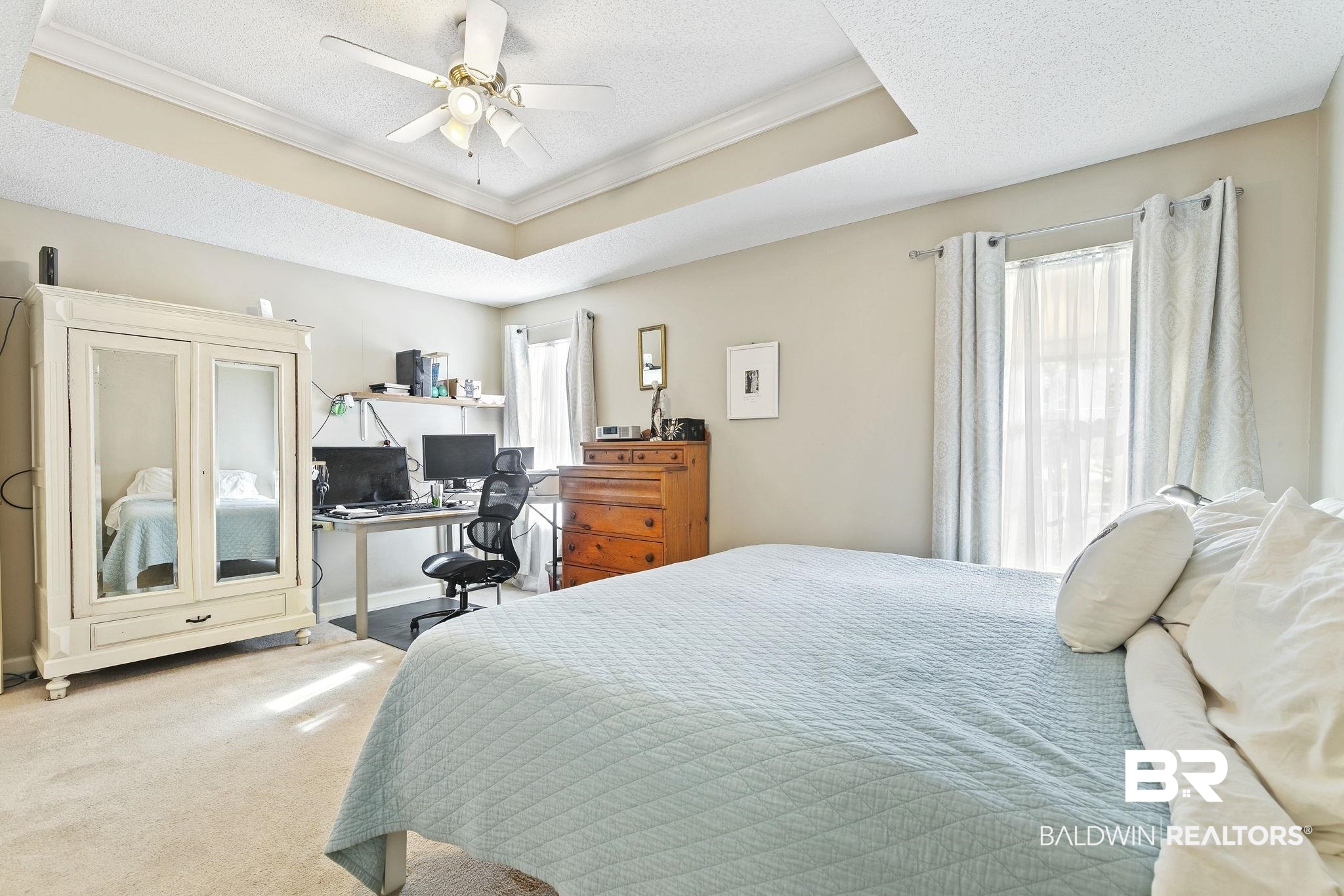22 Pirates Lane Daphne, AL 36527 - Photo 24 of 36 Bedroom featuring carpet, ceiling fan, ornamental molding, and a tray ceiling