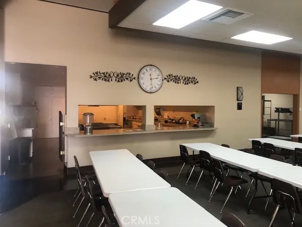 a view of a a dining room with furniture kitchen view and a chandelier