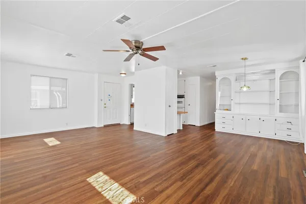 a view of empty room with wooden floor and window