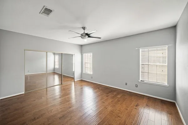an empty room with wooden floor and window