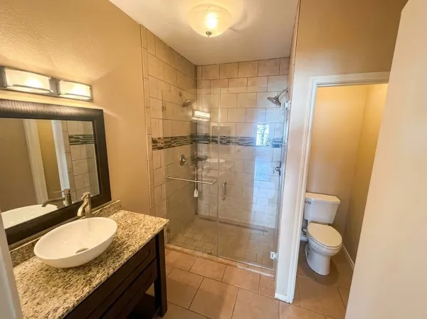 a bathroom with a granite countertop sink toilet and shower
