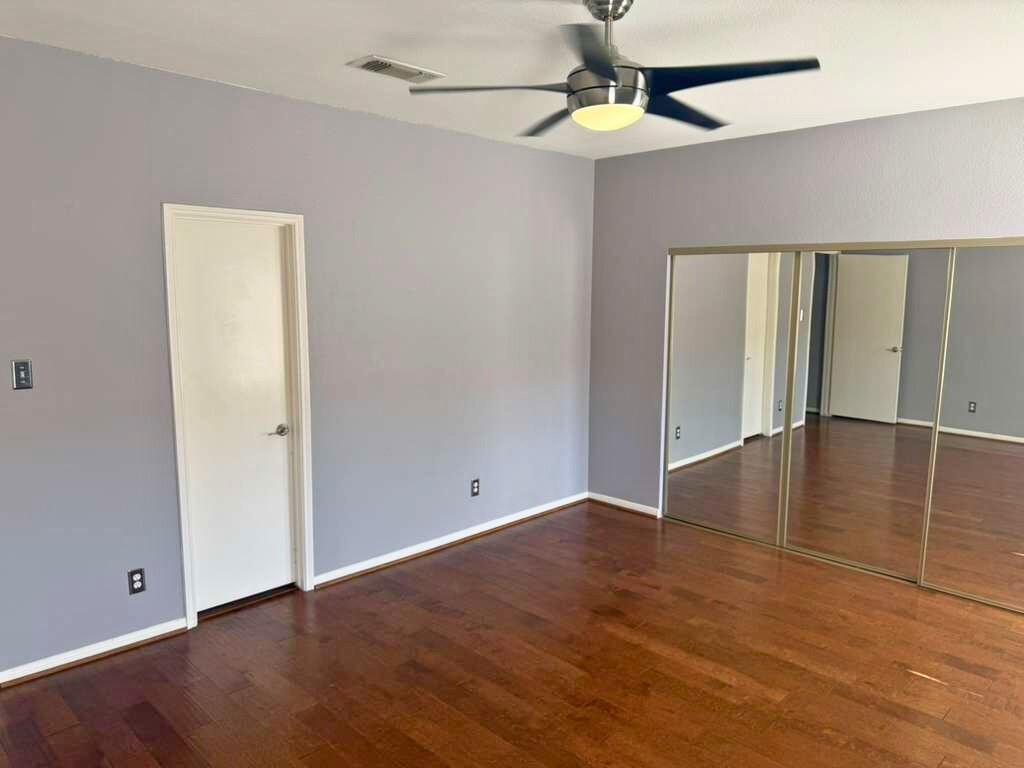 3780 Tanglewilde Street, Unit 306 Houston, TX 77063 - Photo 19 of 22 an empty room with wooden floor ceiling fan and windows