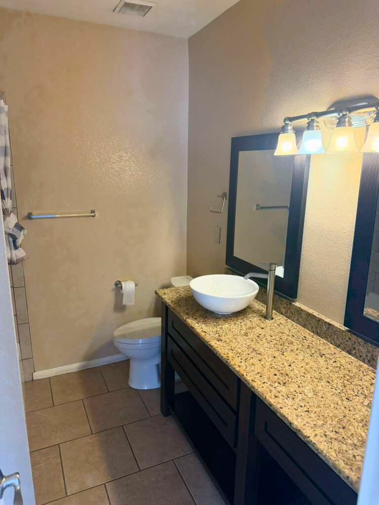3780 Tanglewilde Street, Unit 306 Houston, TX 77063 - Photo 21 of 22 a bathroom with a granite countertop sink and a toilet