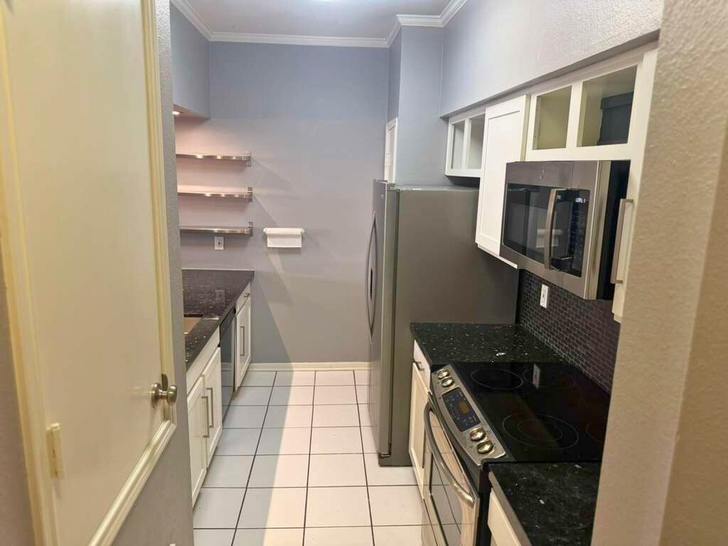 3780 Tanglewilde Street, Unit 306 Houston, TX 77063 - Photo 10 of 22 a kitchen with a refrigerator a stove and cabinets