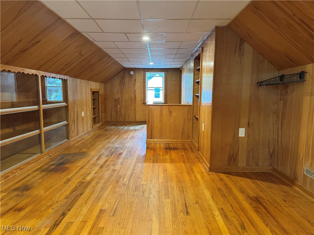 1139 Kessel Avenue Akron, OH 44310 - Photo 17 of 36 Additional living space featuring hardwood / wood-style flooring, wood walls, lofted ceiling, and baseboards