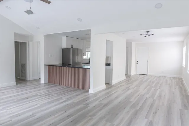 a view of a kitchen with wooden floor and electronic appliances