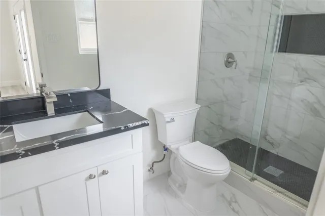 a bathroom with a granite countertop toilet sink and a mirror