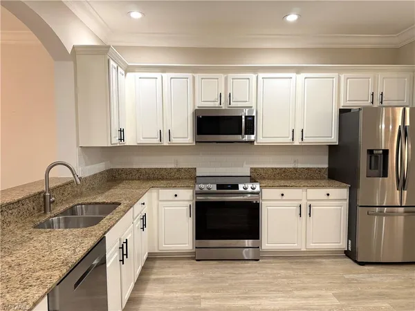 a kitchen with stainless steel appliances granite countertop a stove a sink dishwasher a refrigerator and a microwave