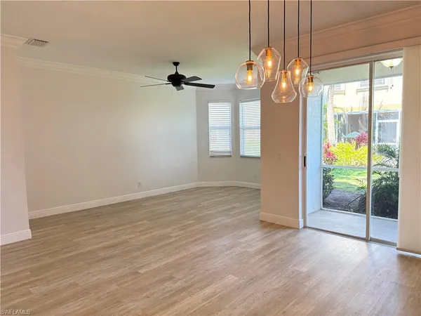 a view of an empty room with glass door and wooden floor