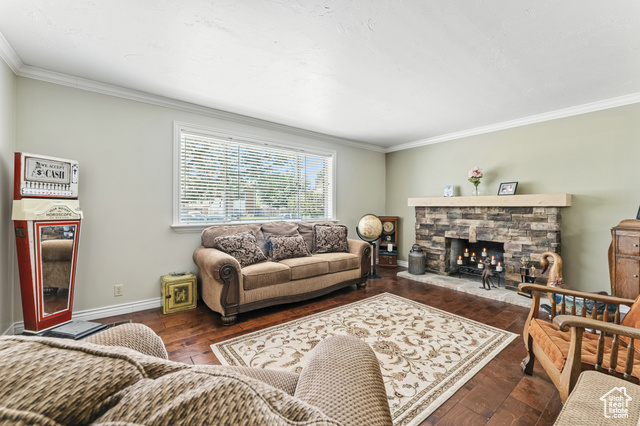 8843 Capernaum Road West Jordan, UT 84088 - Photo 4 of 31 Living area featuring crown molding, dark wood-style floors, and a fireplace