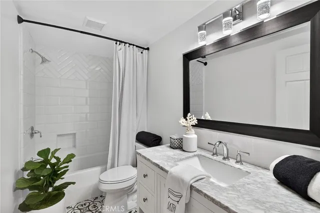 a bathroom with a granite countertop sink toilet and mirror