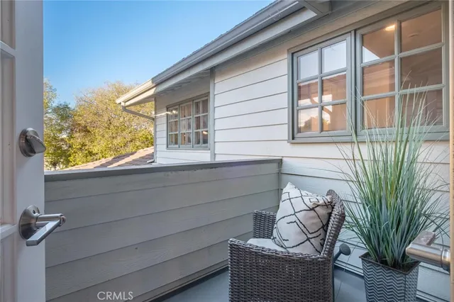 a view of a house with a large window and potted plants
