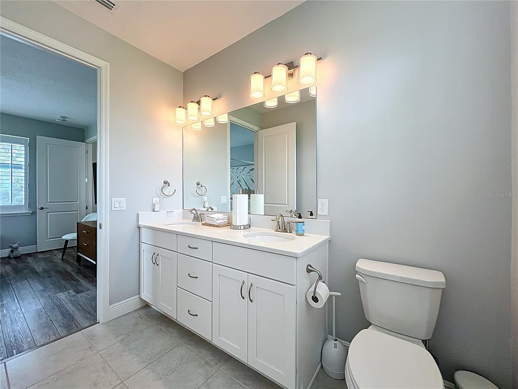10220 Bay Lake Road Groveland, FL 34736 - Photo 53 of 67 a bathroom with a toilet sink and mirror