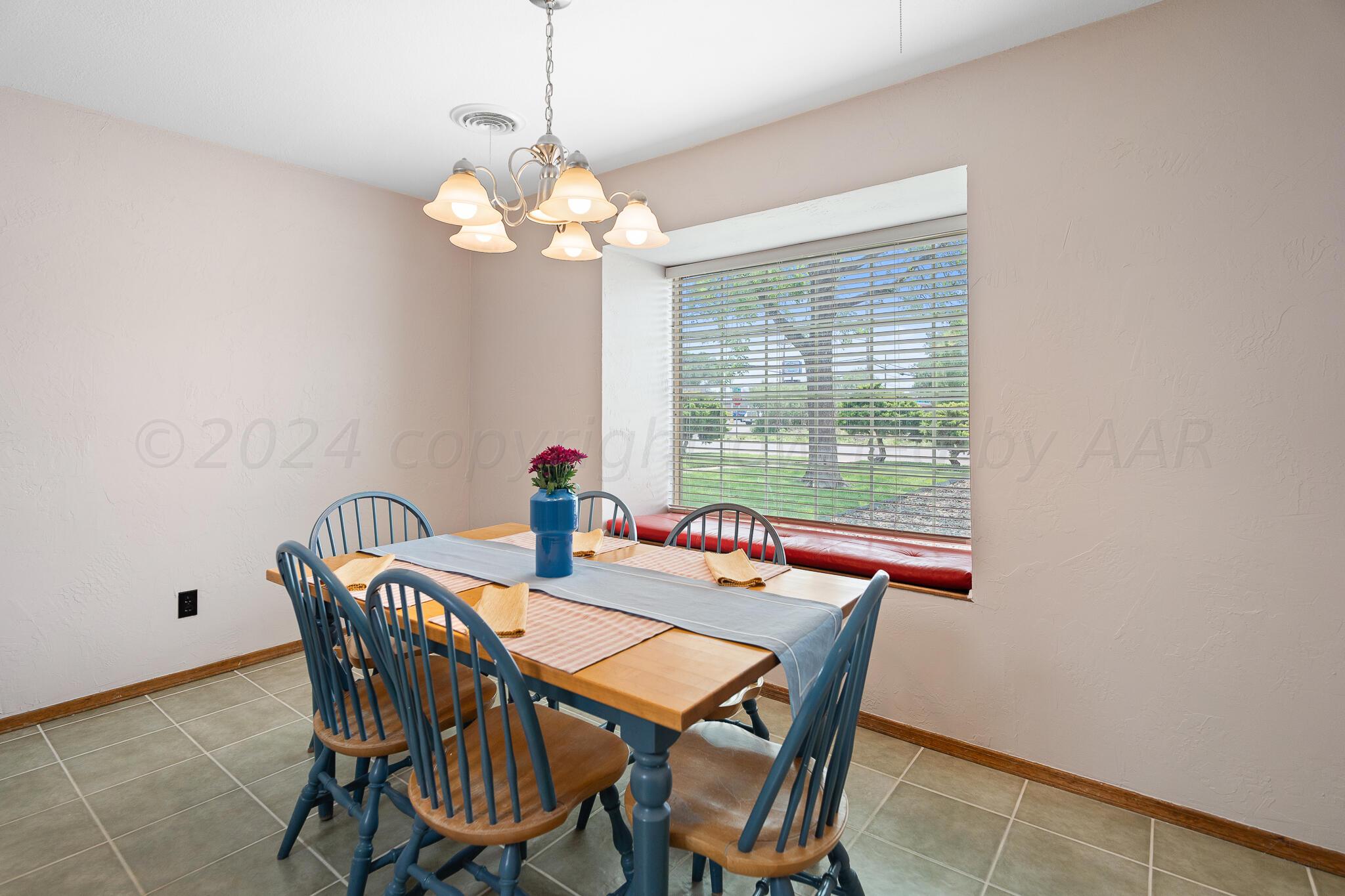 4202 Charles Street Amarillo, TX 79106 - Photo 12 of 25 a dining room with furniture a chandelier and a window