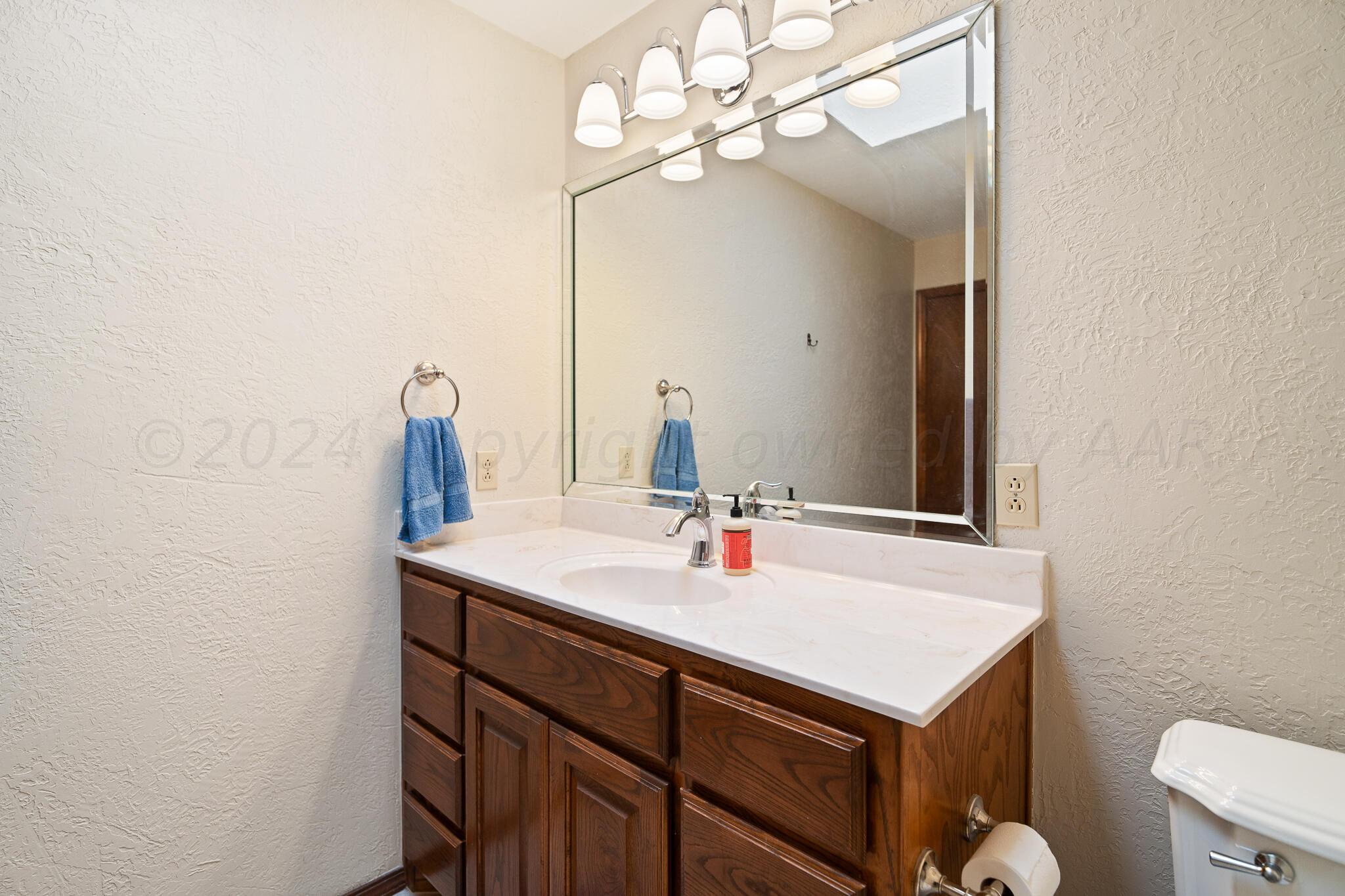 4202 Charles Street Amarillo, TX 79106 - Photo 15 of 25 a bathroom with a sink and a mirror