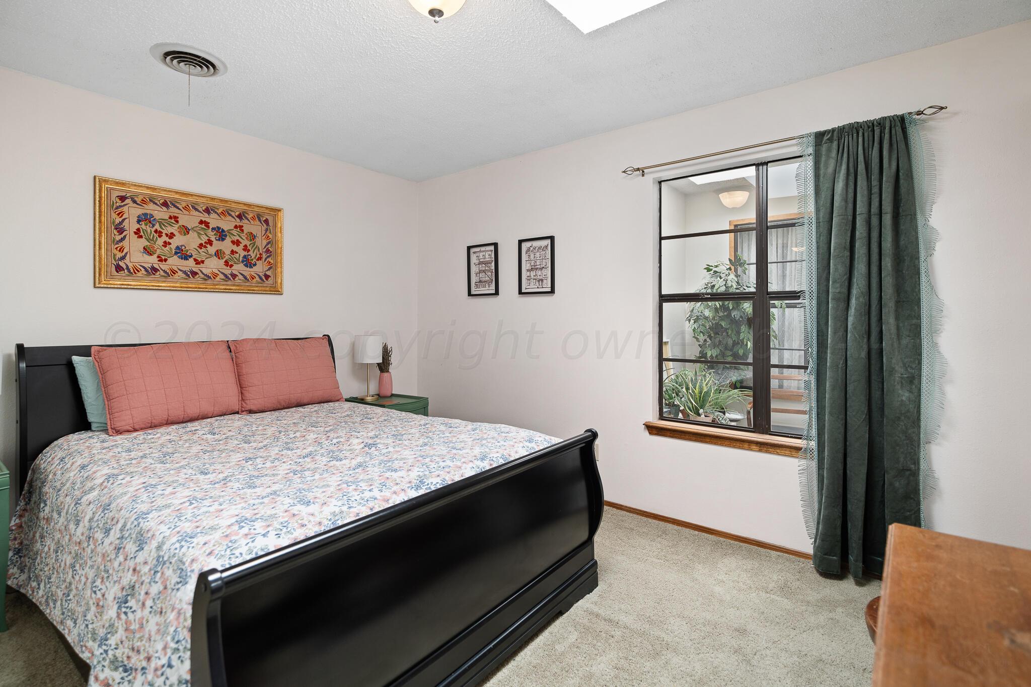 4202 Charles Street Amarillo, TX 79106 - Photo 16 of 25 a bedroom with a bed and window